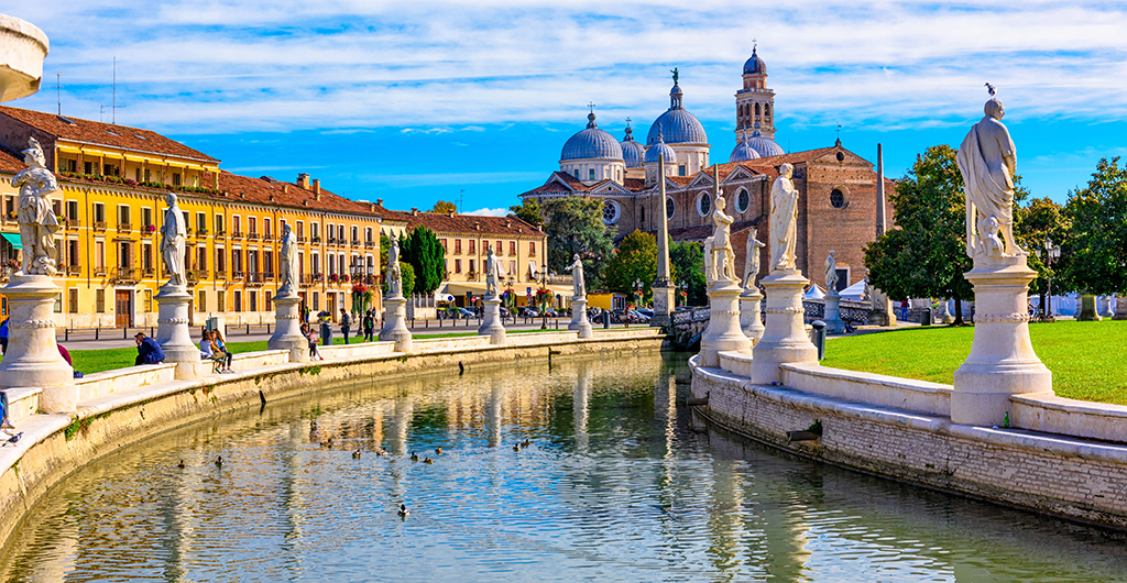 View of canal with statues on square Prato della Valle and Basilica Santa Giustina in Padova (Padua), Veneto, Italy