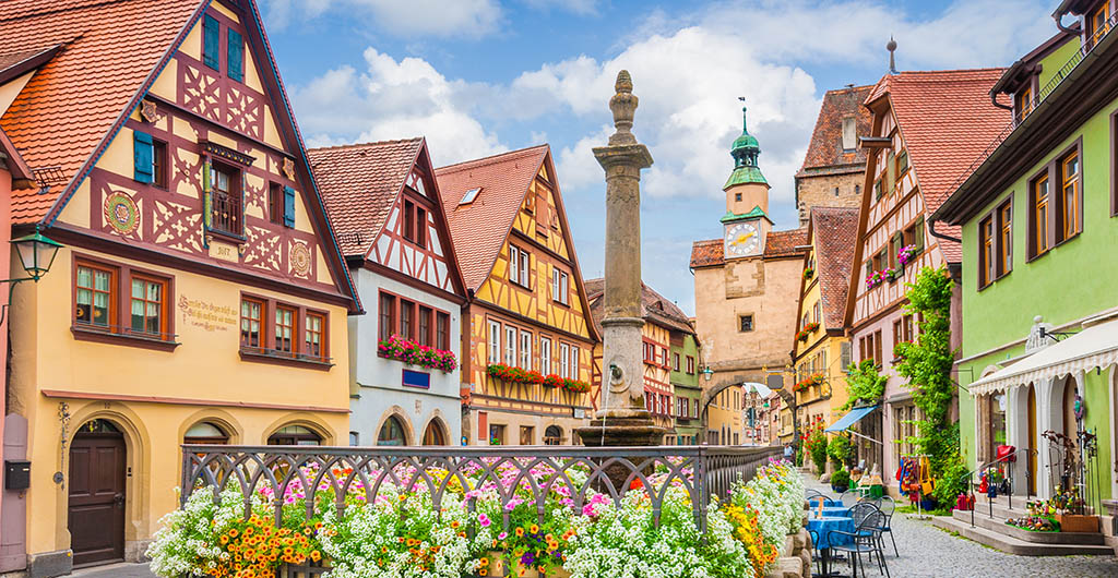 Beautiful postcard view of the famous historic town of Rothenburg ob der Tauber on a sunny day with blue sky and clouds in summer, Franconia, Bavaria, Germany