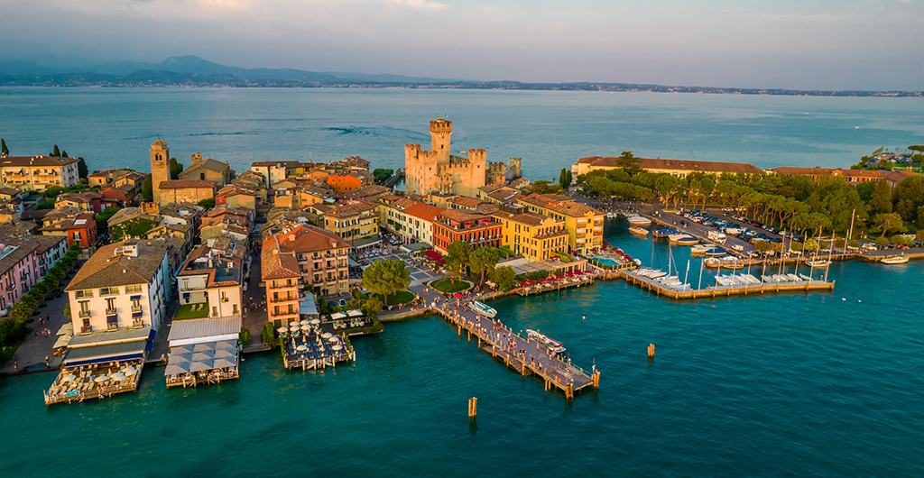Aerial panoramic view of Sirmione city old town on lake Garda in Lombardy, Italy. Evening photo with a castle in a center