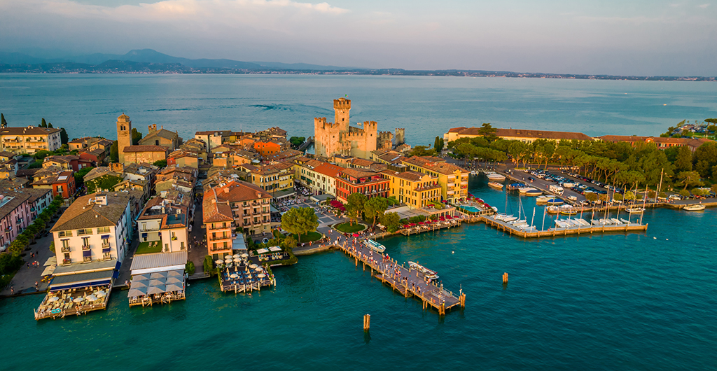 Aerial panoramic view of Sirmione city old town on lake Garda in Lombardy, Italy. Evening photo with a castle in a center
