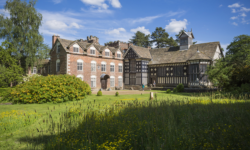 The house and garden in June at Rufford Old Hall, Lancashire. Beautiful Tudor building surrounded by Victorian and Edwardian gardens. The timber-framed manor house was built in the C16th and the brick west front was added in the C17th.