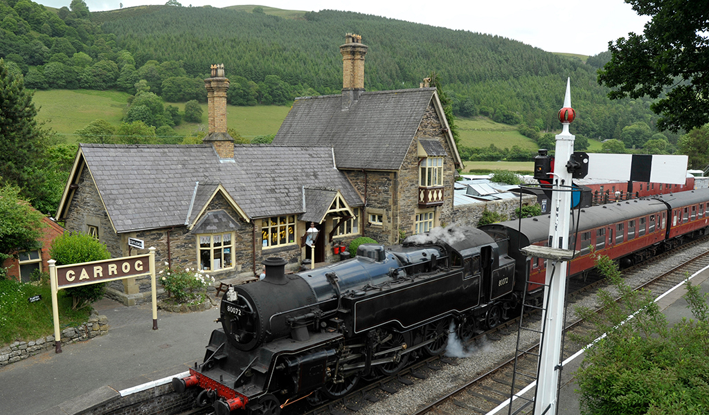 Carrog Railway Station with a standard class 4 tank engine, part of the Llangollen Railway preserved heritage line in the Dee Valley, Denbighshire, Wales, UK.