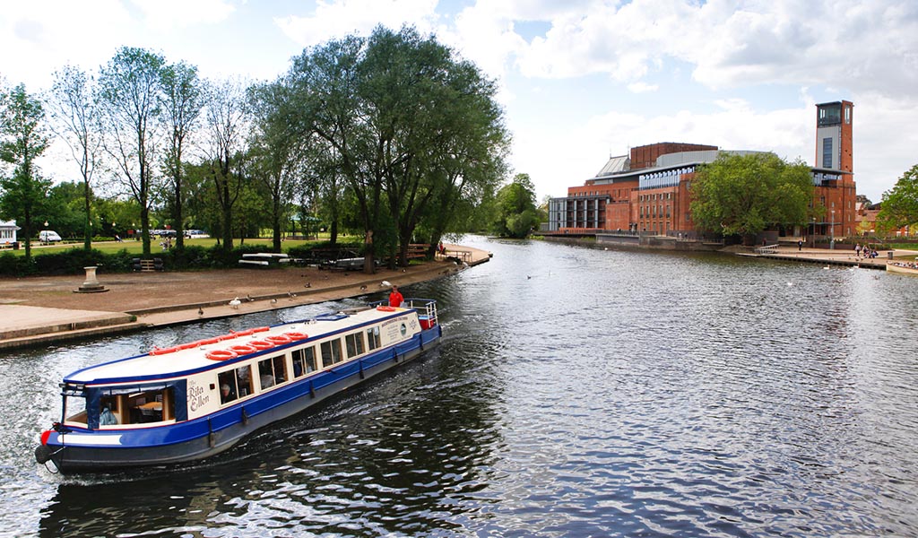Stratford upon Avon, Warwickshire, England, UK. Boat on the River Avon. Royal Shakespeare Company Theatre.